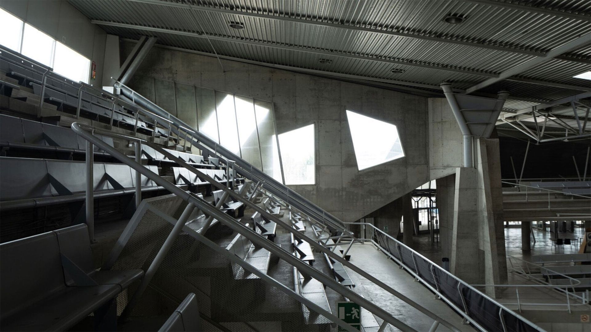 Interior of a building mostly grey with geometric light shapes on the walls