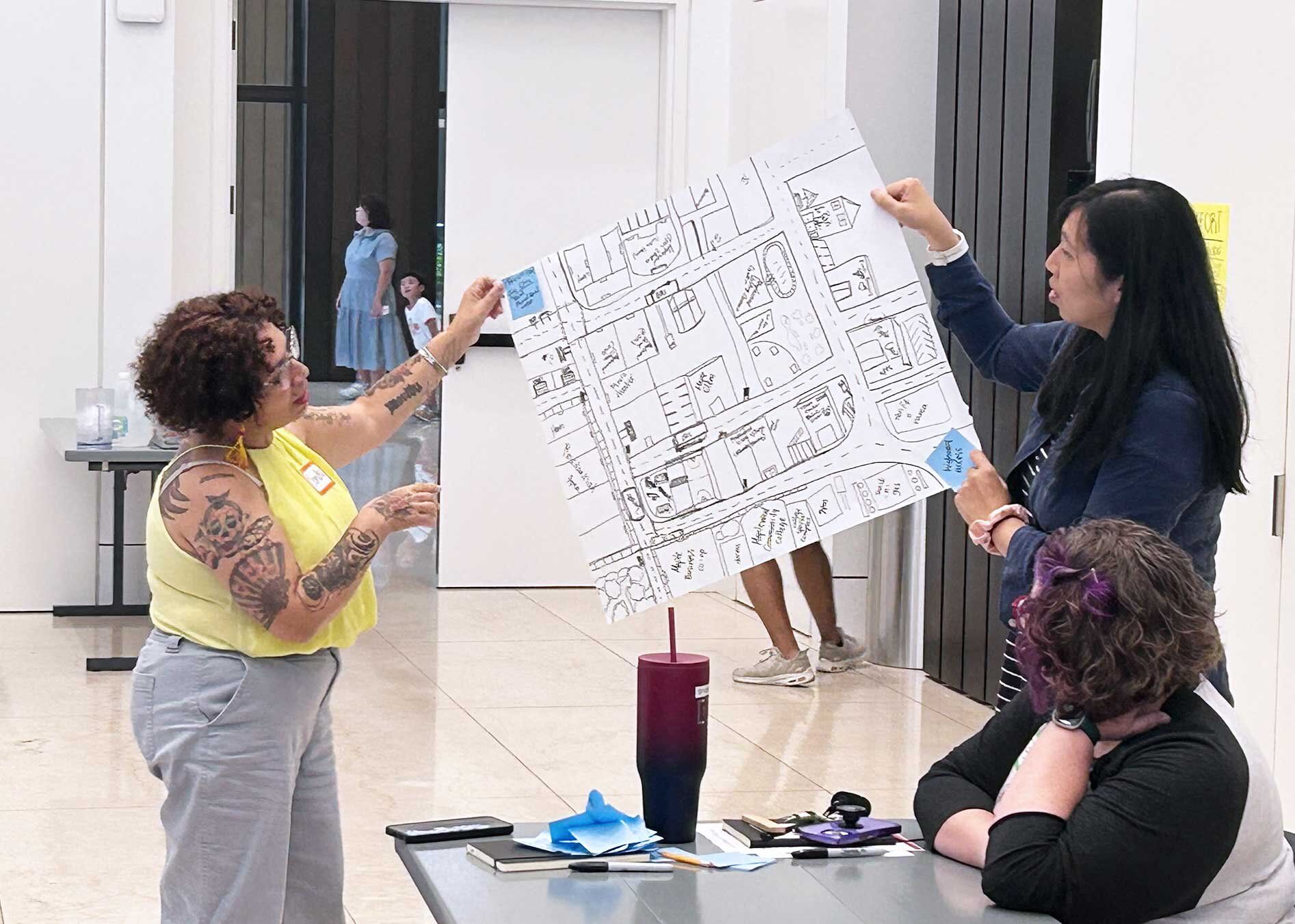 Three women looking on at a handwritten chart