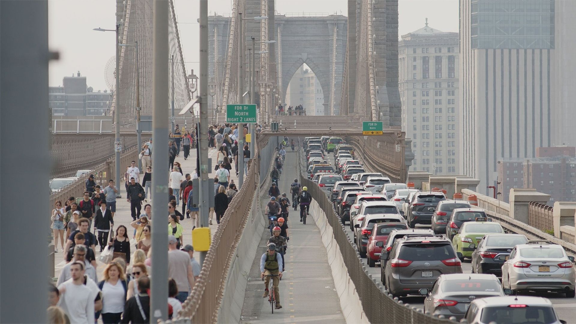 Wide view of a large bridge with cars, bikers and pedestrians
