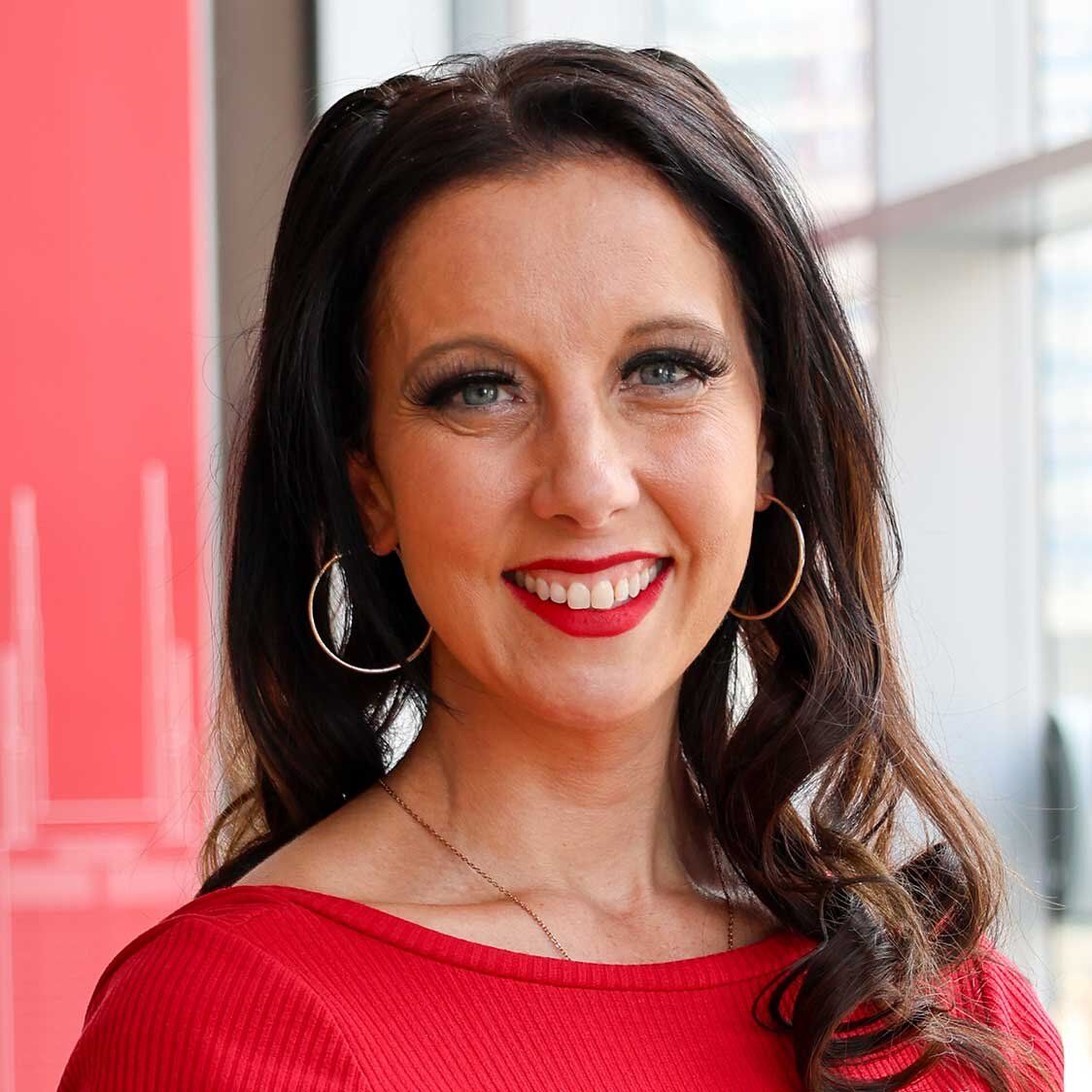 Smiling woman with long brown hair in a red top