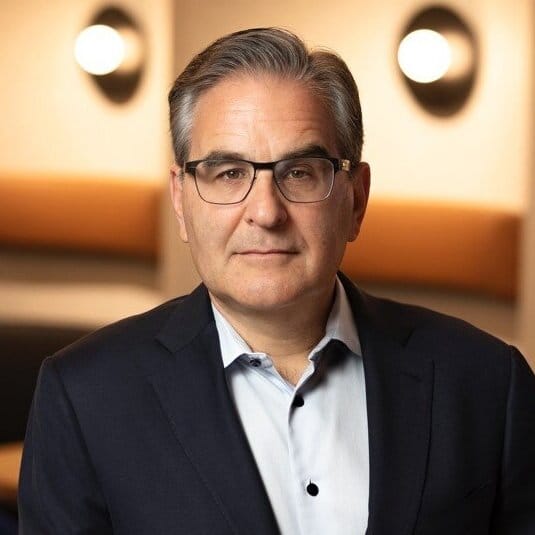 Caucasian male in a suit wearing glasses