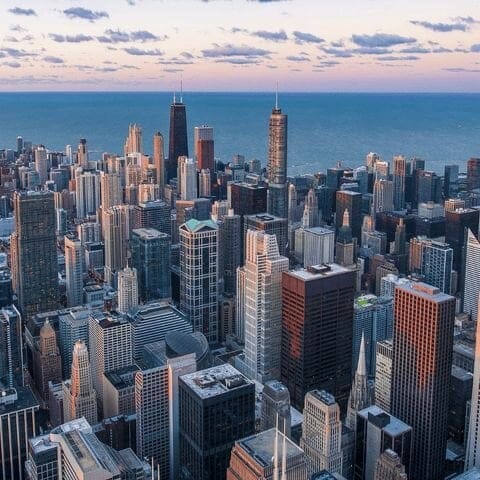 City skyline from above with the lake in the background at sunset.