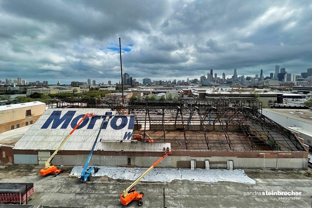 Image of a building under construction with half of the roof removed. 