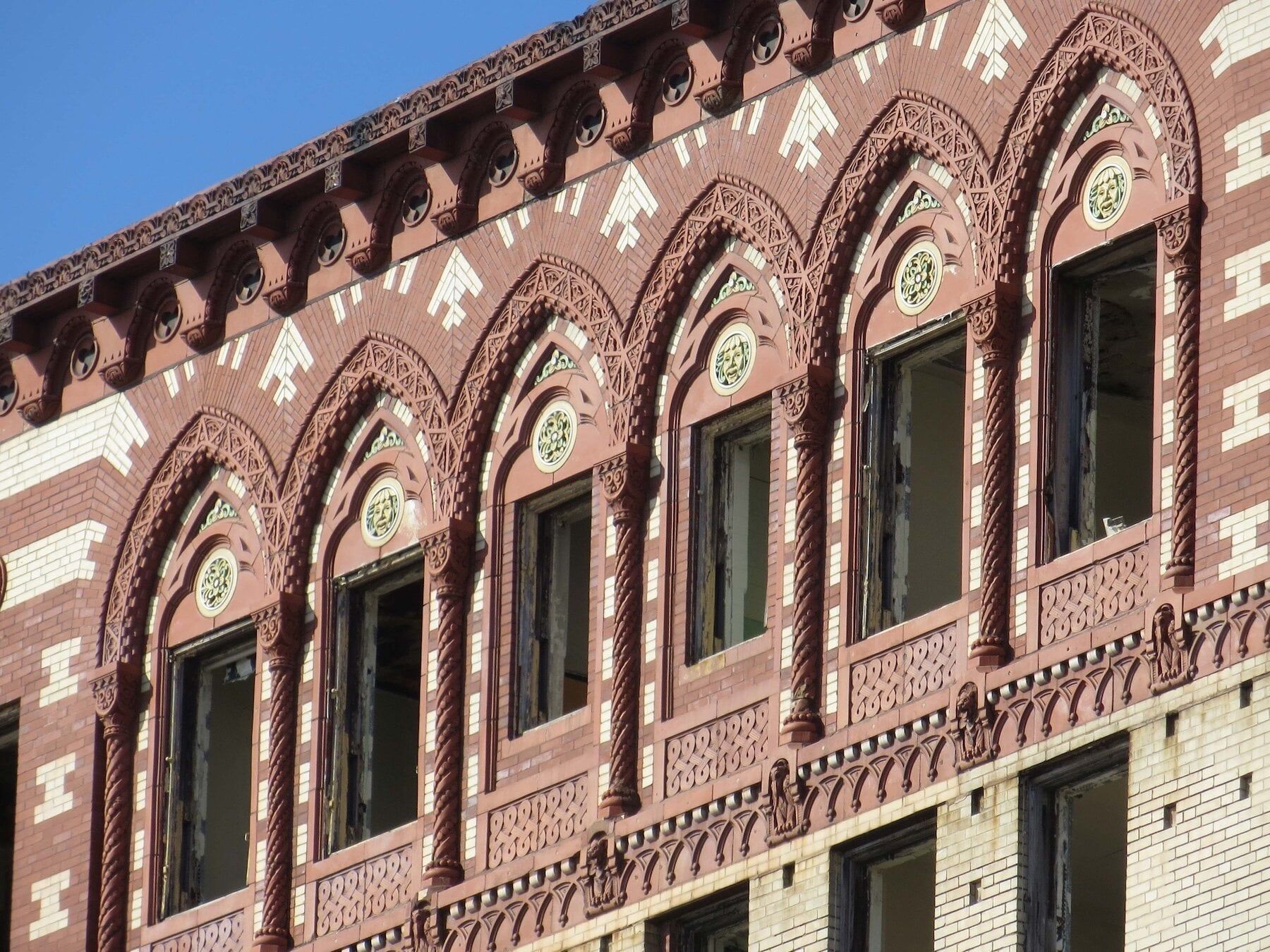 Angle view of a red building with detailed molding around windows.