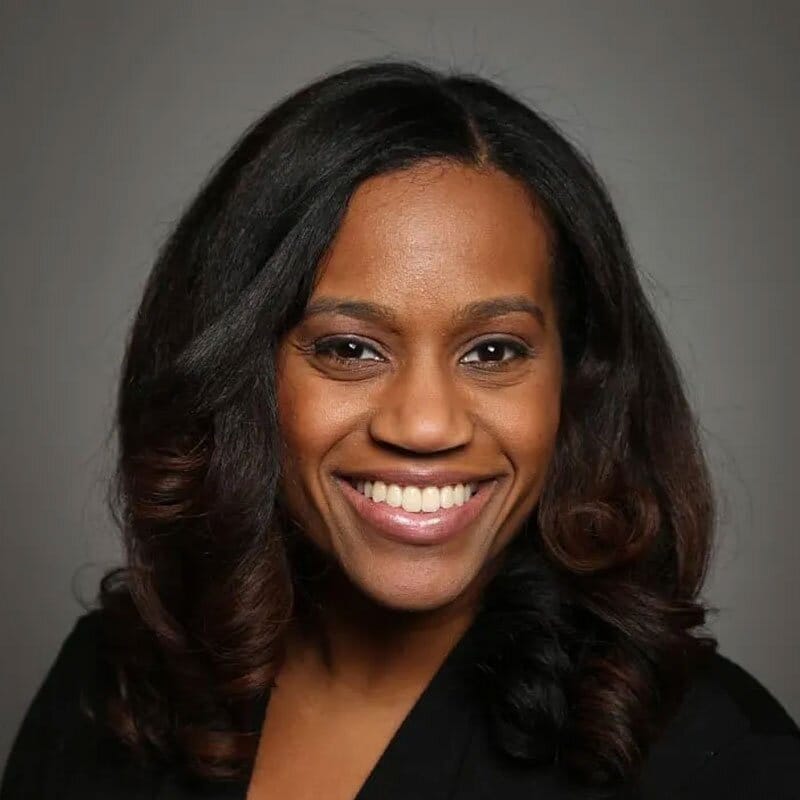 Black woman with shoulder length hair smiling at the camera