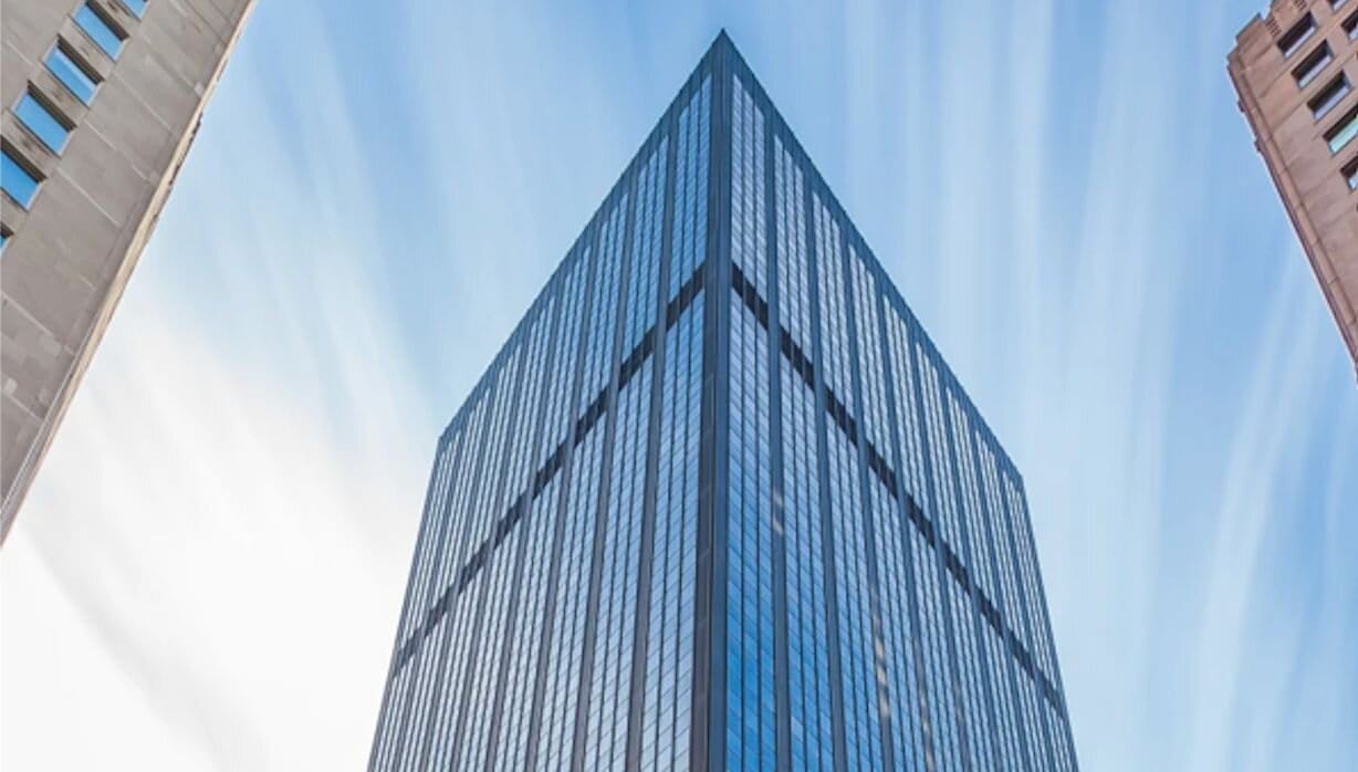 tall blue reflective building against a blue sky.