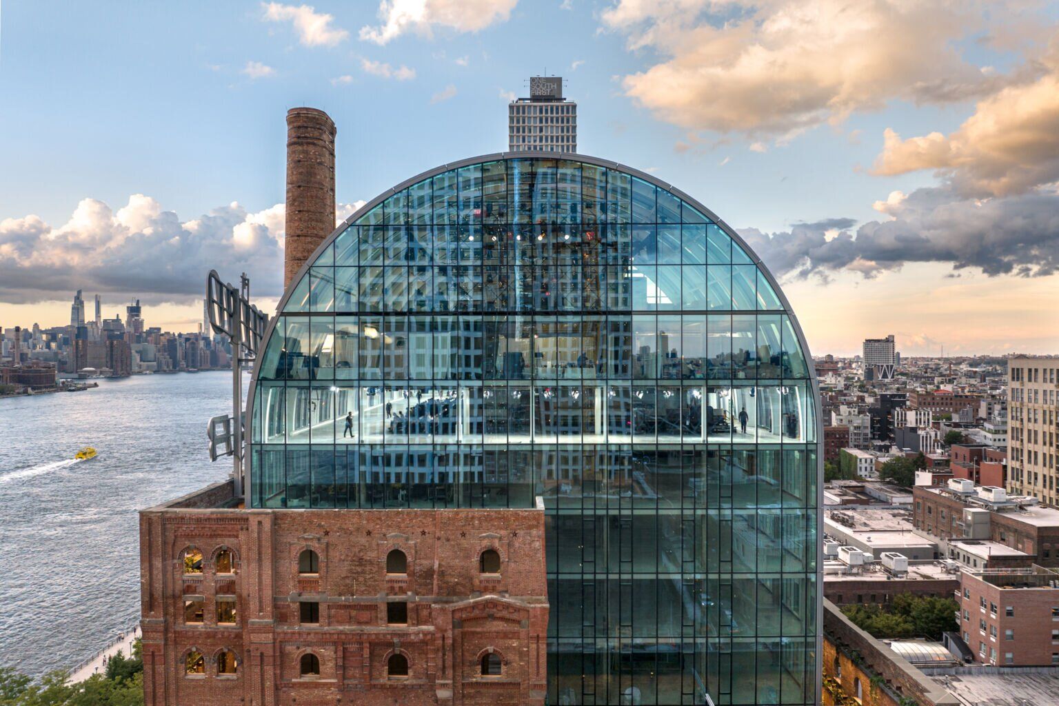 Glass building with a rounded roof and brick base.