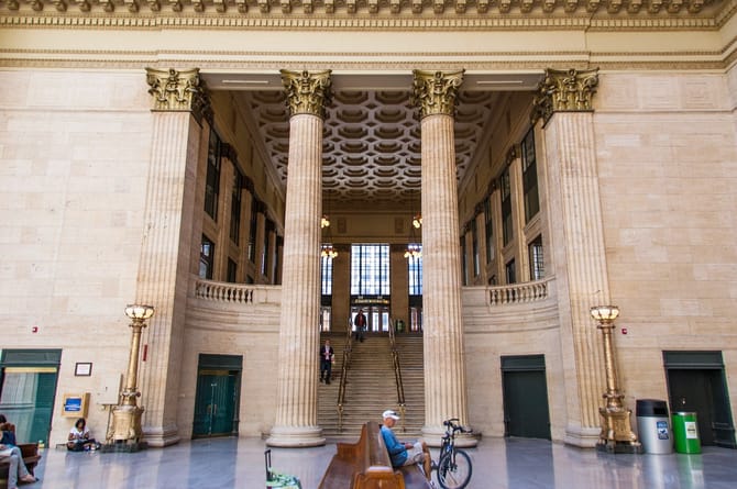 Interior image of a large building with tan walls and large columns.