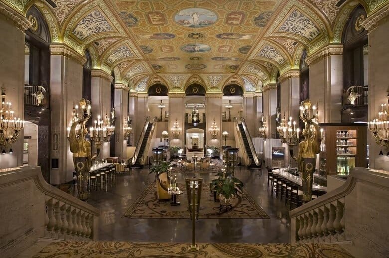 Grand interior of a hotel with lots of seating.