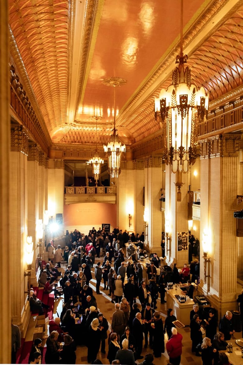 Glowing interior of an opera house filled with people. 