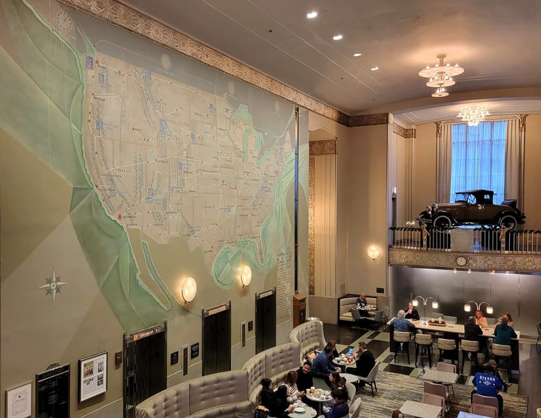 Inside an ornate bank with gold trims and a wall sized map