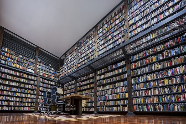 A large library full of multiple levels of books. 