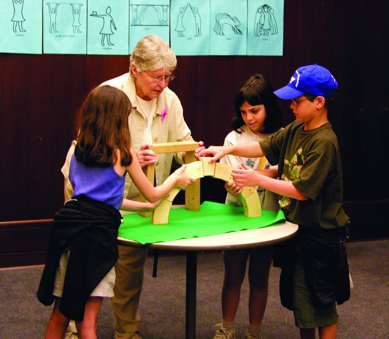 Kids and an adult working on a project together.