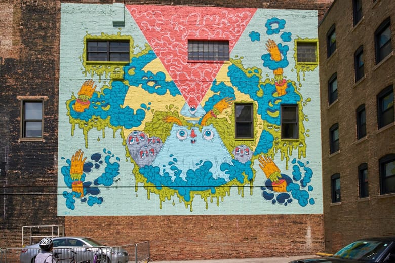 Colorful pizza inspired mural on the entire side of a brick building
