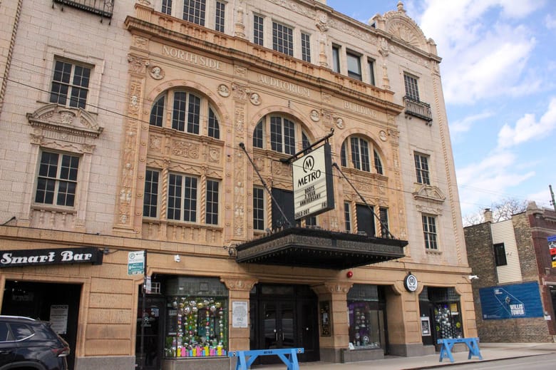 Exterior of a tan building with a detailed ornamentation in the face of the building and a marquee that reads "Metro"