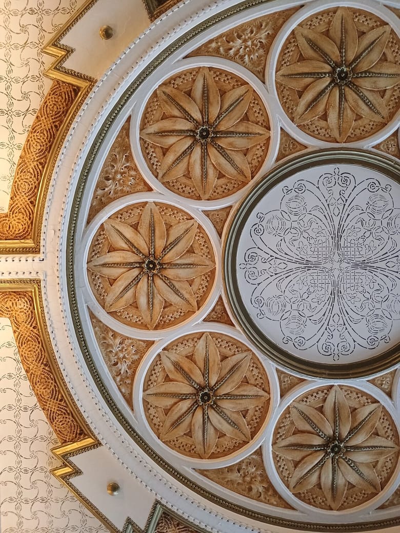An ornate ceiling with many different shapes and floral patterns. 