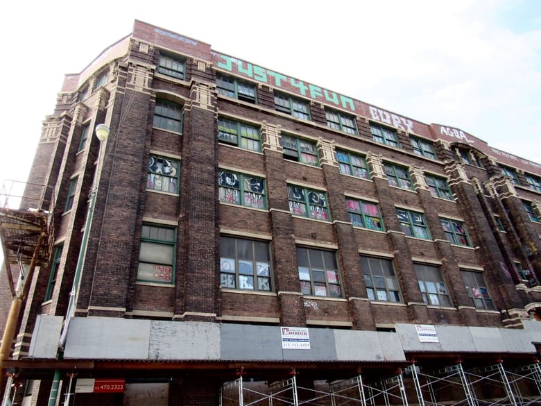 Sculpture of a person on the side of the building, with ornate carvings around it.