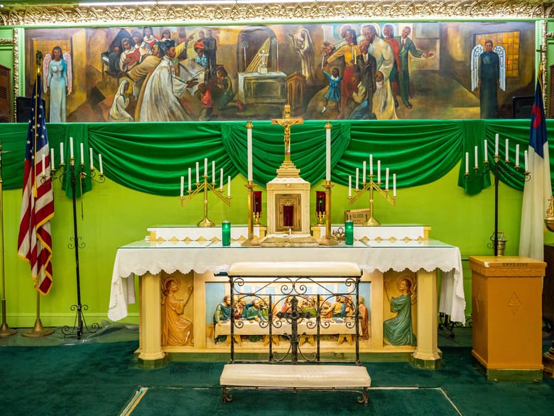 Image of an alter with a green wall behind it. 