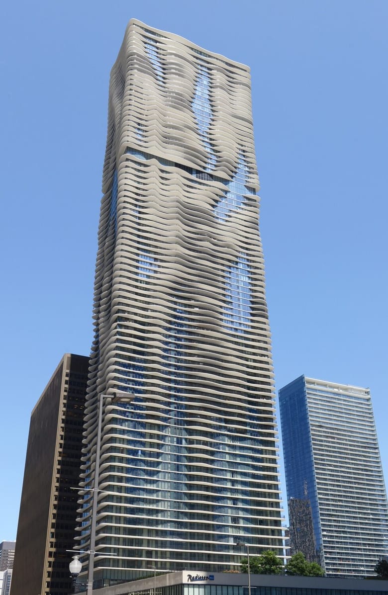 Large ivory building, many stories high, with curved balconies.