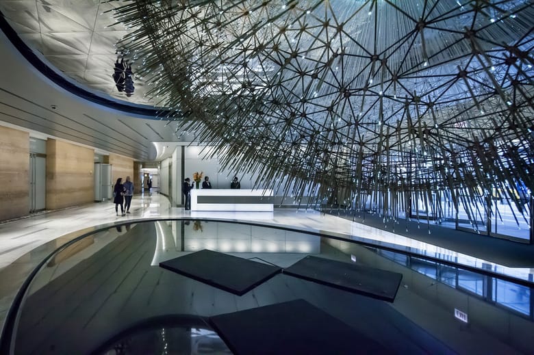 An office building lobby with a large spherical sculpture