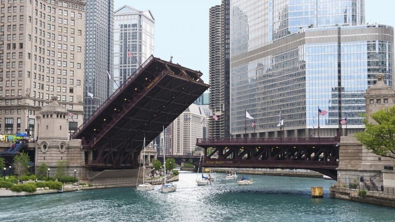 Bridge over a river that is partially lifted from the left side to create room for boats underneath