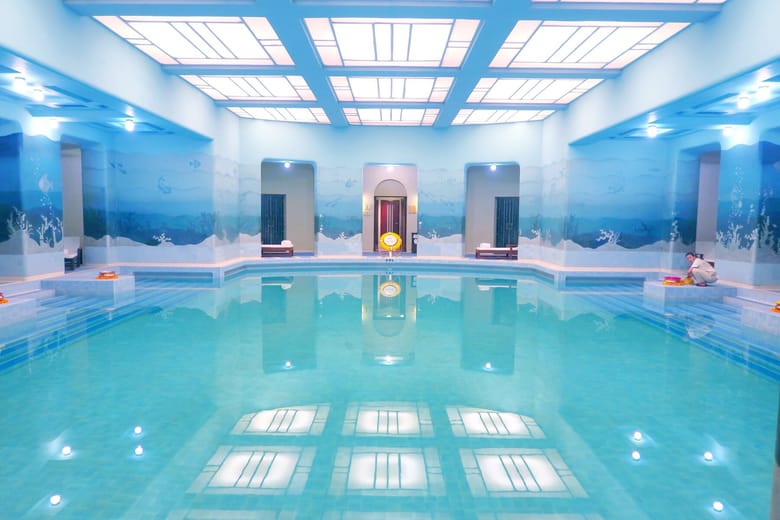 bright blue image of an indoor swimming pool.