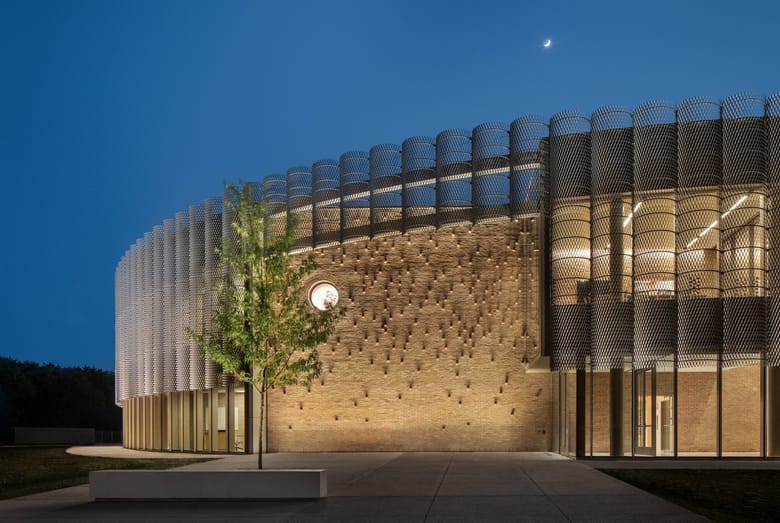 Exterior of a building with a curved facade at night. 