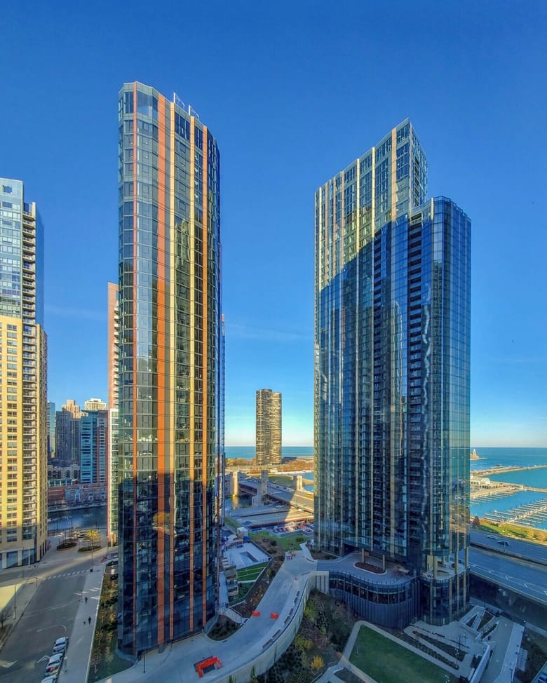 Two tall glass skyscrapers overlooking Lake Michigan.