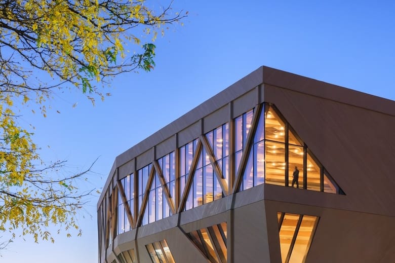 Wooden and glass building at dusk.