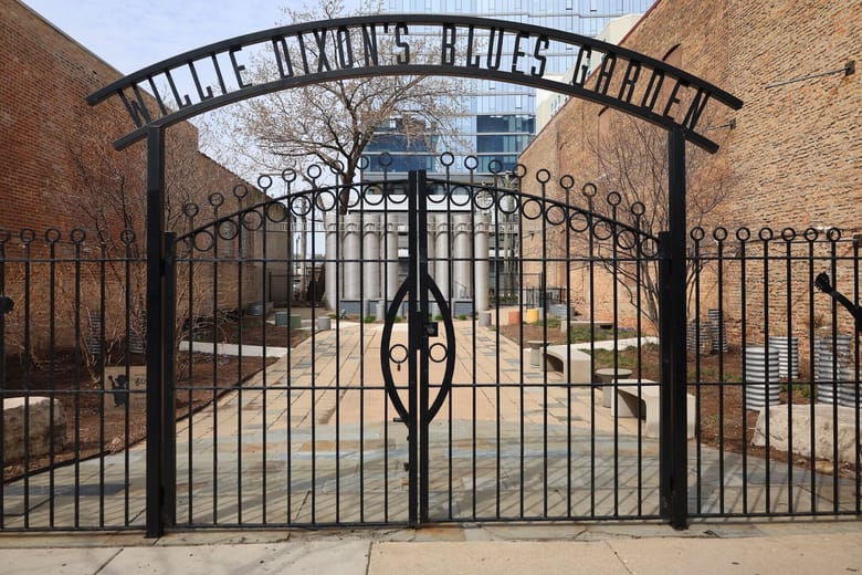 Black iron gate on a fall day.