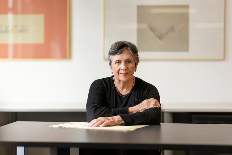caucasian woman with short grey hair sitting at desk 