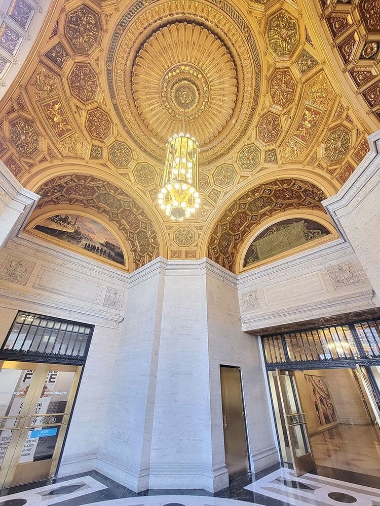 Inside and looking up to a beautiful gold ceiling with detailed designs