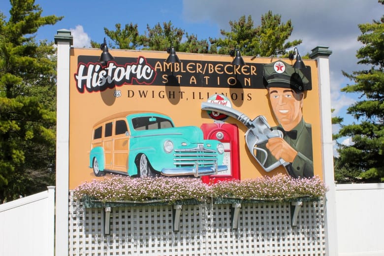 Yellow billboard with blue truck and cartoon graphics on it. 