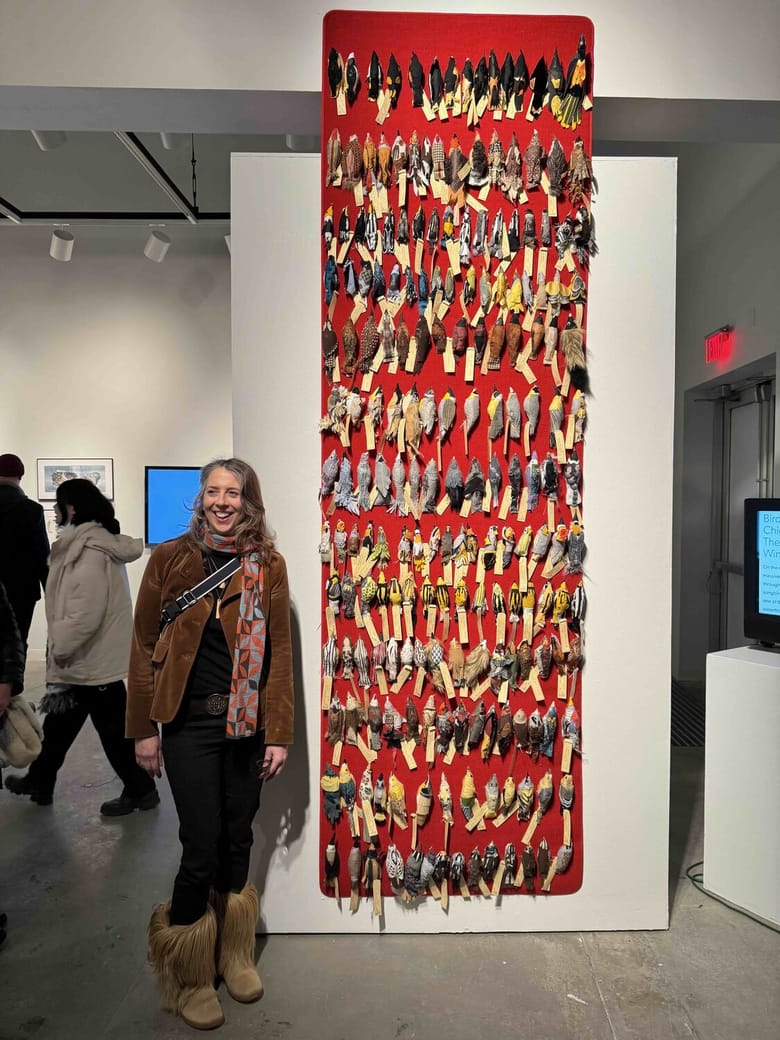 Woman standing in front of a bird art piece.