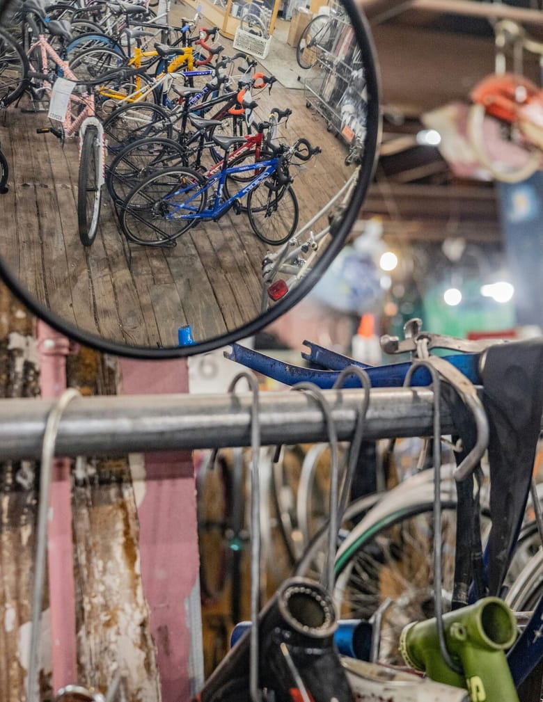 A round mirror in the top left corner reflects a line of bikes while more bikes are also visibile in the background behind the mirror.