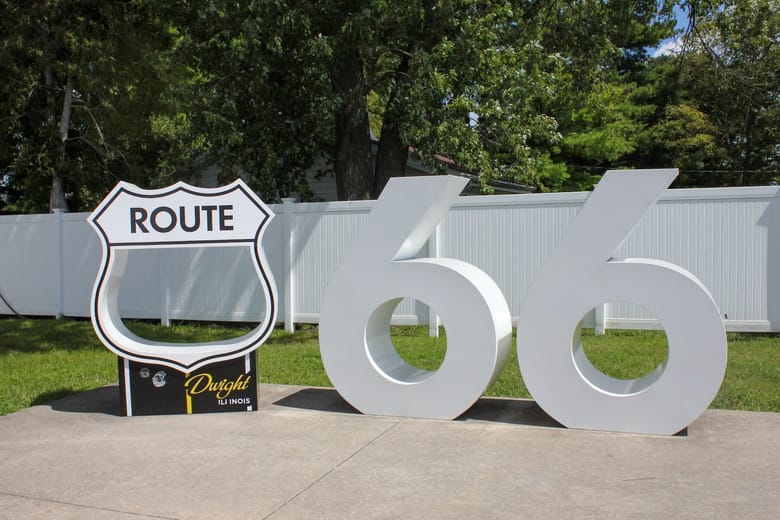 White route 66 sign in a lush green setting