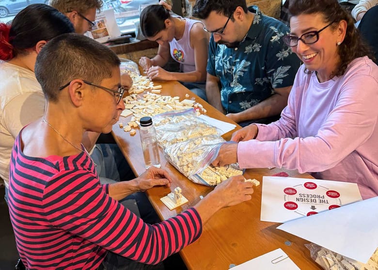 People seated working on a lego build