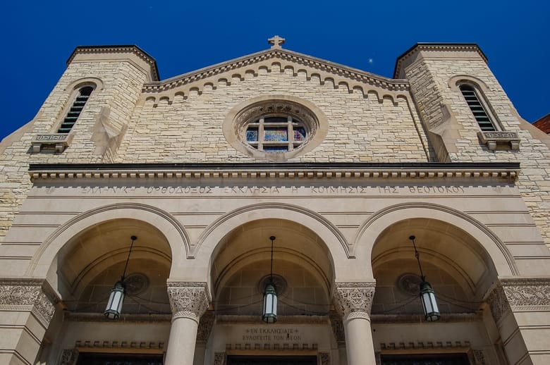 Exterior of a cream colored church on a sunny day.