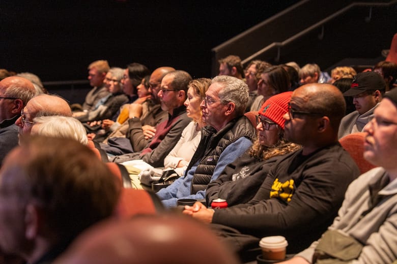 People in a theater watching a film. 