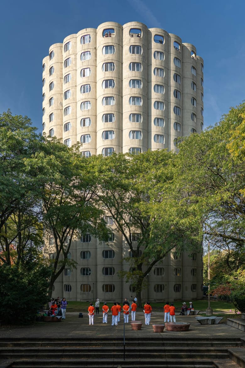 Tall round tower building with trees in front.
