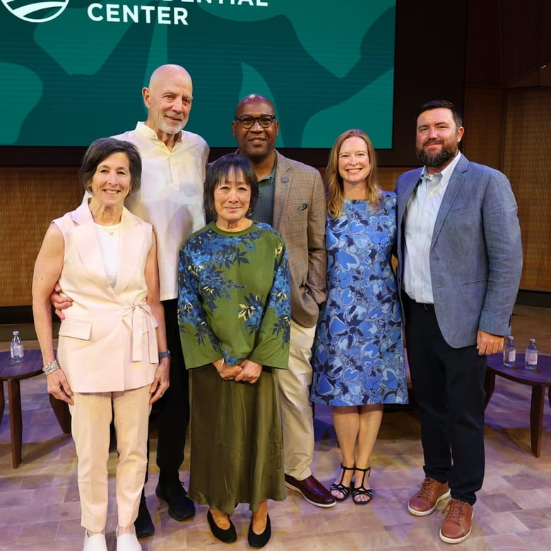 Six people standing on a stage together.