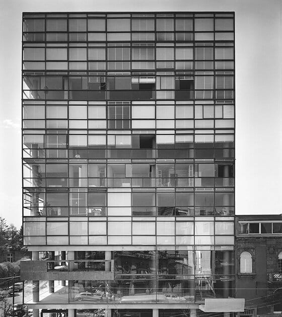 Black and white photo of an office building with lots of windows.