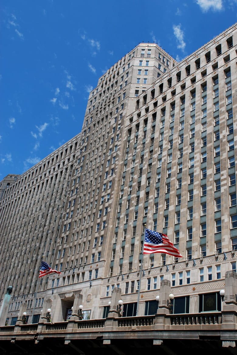 Exterior of large white building, looking up from the ground