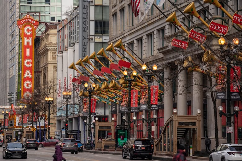 Exterior of an old building with Christmas lights and decor at street level.