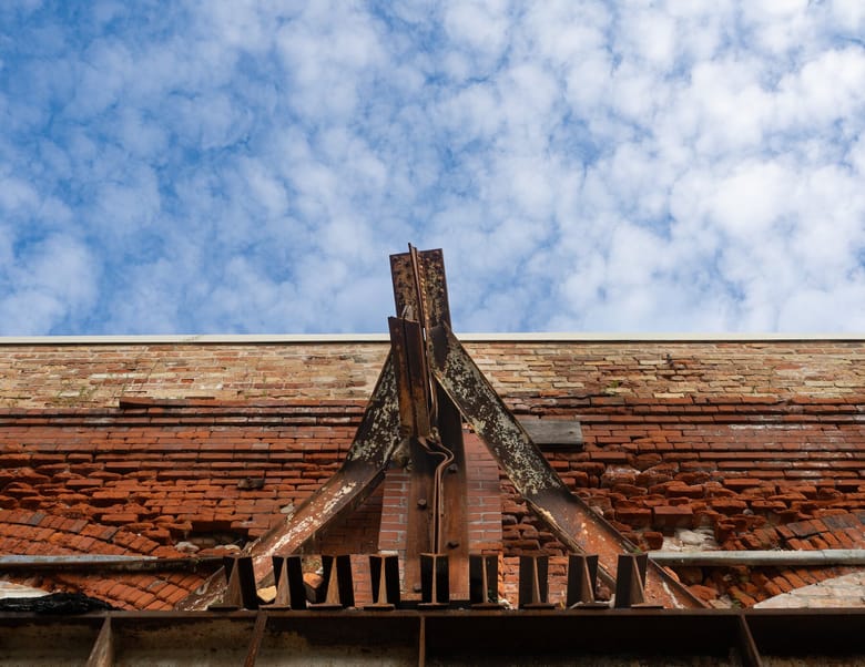 The side of a red brick building, with a blue sky in the background.
