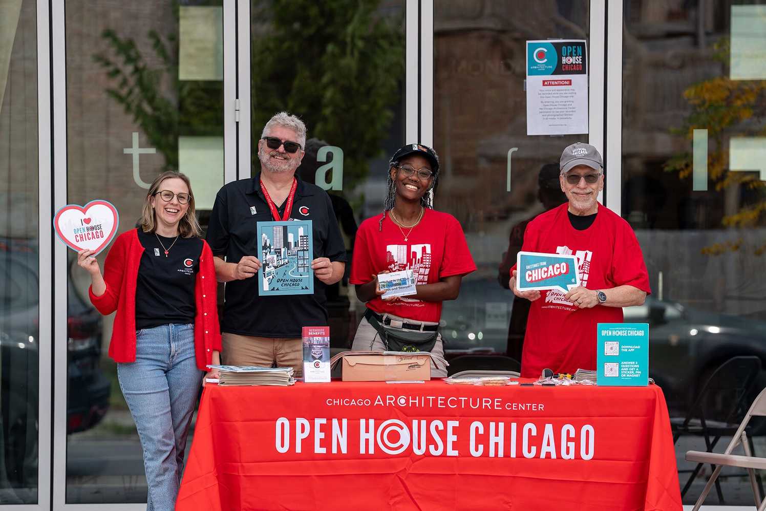 A diverse group of four volunteers smiling with "I love OHC" signs